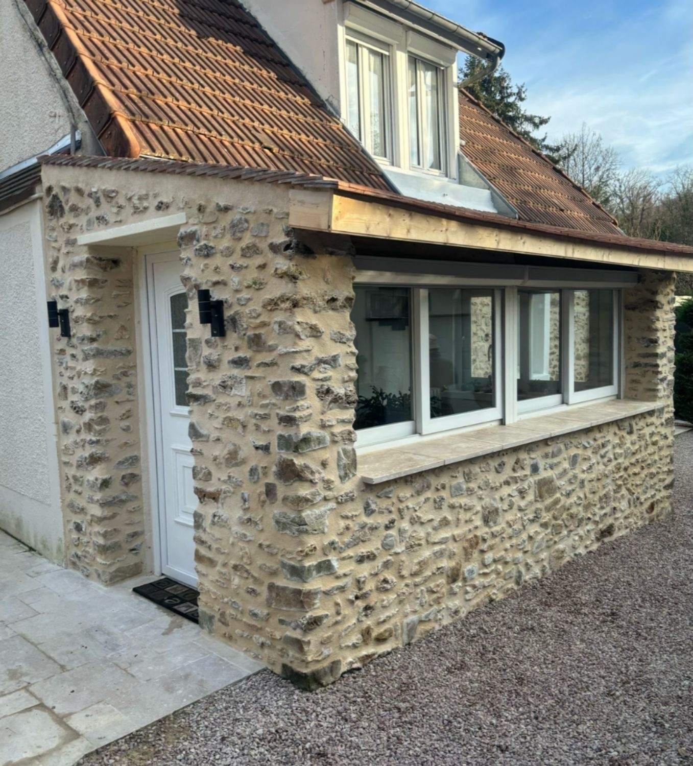 Véranda habillée en pierre après travaux réalisés par FLV Concept à Dourdan